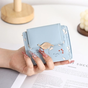 Close-up of light blue PU leather wallet with gold leaf clasp and cherry patterns