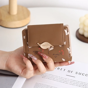 Detailed view of brown PU leather folding wallet with gold leaf clasp and floral prints