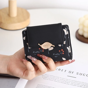 Close-up of black PU leather floral wallet with pink petals and golden leaf buckle