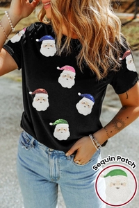 Détail des patchs Père Noël en paillettes colorées sur un T-shirt de Noël noir à manches