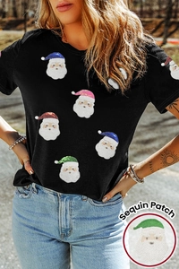 Détail de patchs en paillettes colorées motif Père Noël sur un t-shirt noir en coton