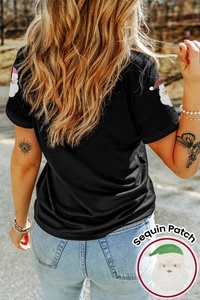 Détail du patch Père Noël en paillettes brillantes sur un T-shirt en coton noir