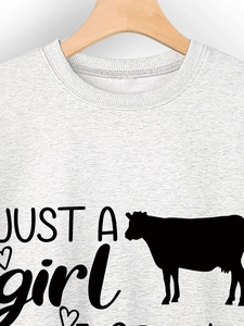 Close-up of crew neck sweatshirt ribbing and cow graphic print with heart art text