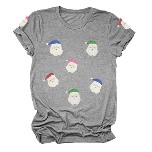 Détail d'un t-shirt de Noël gris avec imprimés de Père Noël colorés en paillettes
