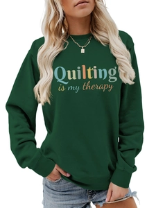 Close-up of Quilting is my therapy colorful text print on dark green cotton sweatshirt