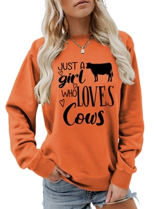Detail of printed Just a Girl Who Loves Cows slogan on a bright orange sweatshirt