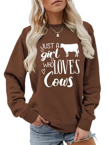 Detail of the white heart and cow silhouette print on a brown crewneck sweatshirt