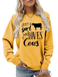 Close-up of yellow sweatshirt featuring Just a Girl Who Loves Cows text and cow graphic