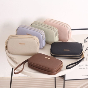 Close-up of colorful lychee grain leather bags with gold logo and dual zippers