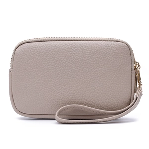 Close-up of pebble leather texture and gold zipper on apricot minimalist wristlet pouch
