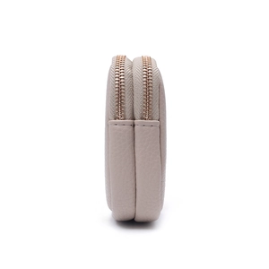 Detail view of double-zipper structure and pebble grain texture on a minimalist pouch