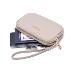 Detail of lychee pattern leather wallet with gold zipper and passport storage