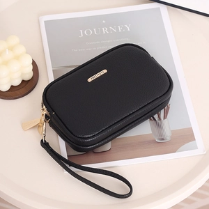 Detail of black pebbled PU leather wallet with gold hardware and dual zipper closure