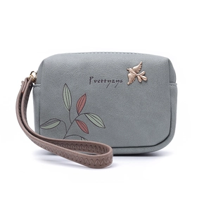 Detail of grey PU leather wallet featuring bird metal clasp and floral leaf prints