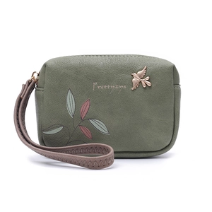 Detail view of the sage green PU leather clutch with gold bird charm and leaf prints