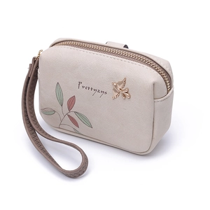 Close-up of cream PU leather wallet with floral print and bird metal emblem detail