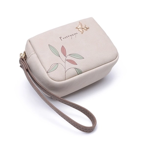 Close-up of beige PU leather floral wallet featuring golden bird metal charm and wristlet