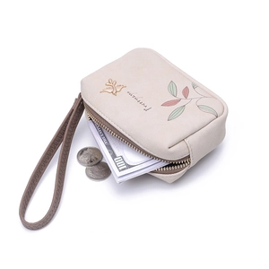 Detail of leaf pattern PU leather wallet with gold bird accent and wrist strap