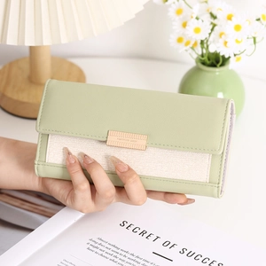 Detail of light green leather and tweed long wallet with gold metallic hardware