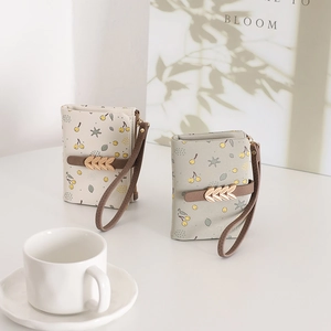 Détail de portefeuilles courts à fleurs pour femmes avec boucle dorée et dragonne