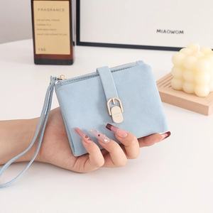 Gros plan du mini portefeuille bleu clair avec boucle dorée et dragonne assortie