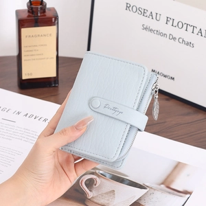Close-up of light blue lychee pattern leather wallet with gold leaf zipper puller detail