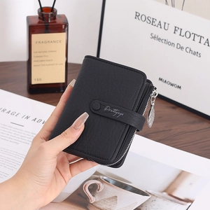 Close-up of black leather wallet with leaf-shaped metal zipper pull and snap closure