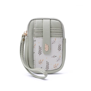 Détail du mini sac en cuir vert clair avec motif floral et décor de feuilles en métal