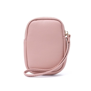 Détail de la texture cuir litchi rose et fermeture éclair métallique sur la pochette