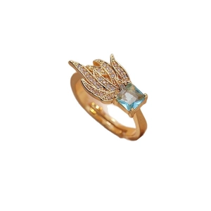 Adjustable gold ring featuring square blue gemstone and cubic zirconia feather details