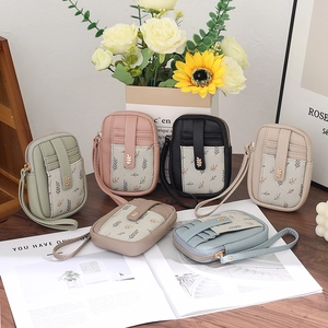 Vue à plat de mini sacs bandoulière en nylon fleuri en six couleurs sur table en bois