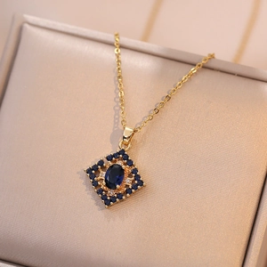 Elegant gold clover necklace with deep blue gemstones and oval zircon on display box