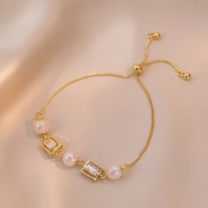 Adjustable gold bracelet with white pearls and square zircon on champagne satin