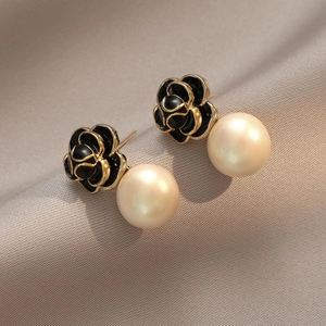 Boucles d'oreilles vintage rose émail noir avec perles et bordure dorée sur tissu en soie grise