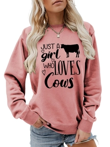 Detail of dusty rose sweatshirt featuring black cow print and artistic typography