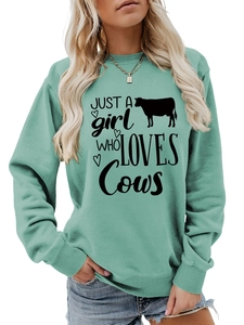 Detail of mint green cotton sweatshirt featuring black 'Just a Girl Who Loves Cows' print