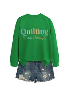 Flat lay of green sweatshirt with Quilting Is My Therapy text and ripped denim shorts