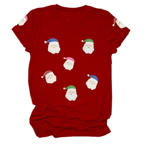 Détail du t-shirt de Noël rouge avec motifs de têtes de Père Noël en sequins colorés