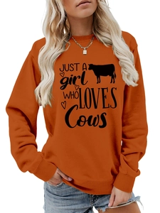 Detail of orange crewneck sweatshirt featuring a black cow silhouette and artistic text print