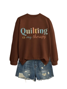 Flat lay of brown 'Quilting is my therapy' sweatshirt and distressed denim shorts