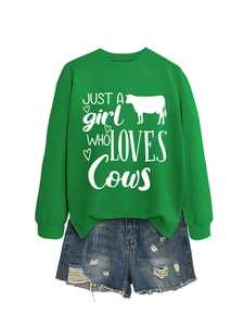Detail of green cow print sweatshirt paired with distressed denim shorts for women