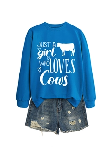 Flat lay of royal blue cow print sweatshirt set with distressed denim shorts