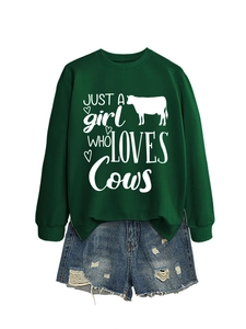 Flat lay of a green sweatshirt with cow print and distressed denim shorts ensemble