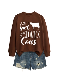 Flat lay of brown 'Just a girl who loves cows' sweatshirt with ripped denim shorts
