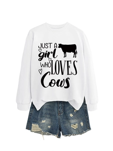 Detail of distressed denim shorts with raw hem and white sweatshirt cow print