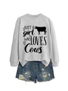 Flat lay of gray long-sleeve sweatshirt with cow print and ripped denim shorts set