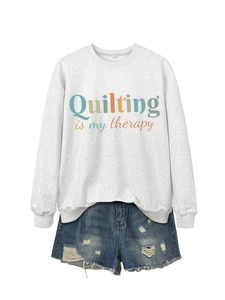 Detail of grey sweatshirt with Quilting is my therapy text and distressed denim shorts