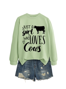 Detail of light green sweatshirt with cow graphic and distressed denim shorts