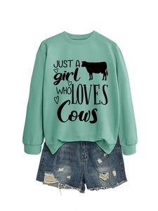 Detail of mint green sweatshirt with Just A Girl Who Loves Cows print and denim shorts