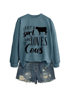 Detail of blue cows print sweatshirt paired with distressed denim shorts on white background